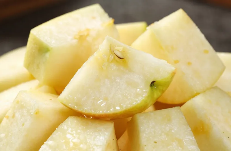 愛犬に安全なリンゴの与え方。窒息や消化不良を防ぐため、種と芯を取り除きサイコロ状に細かくカットしたリンゴの写真。