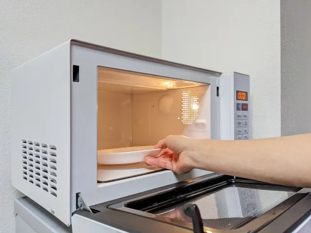 電子レンジで水を加えたドッグフードを温め、柔らかくしている様子